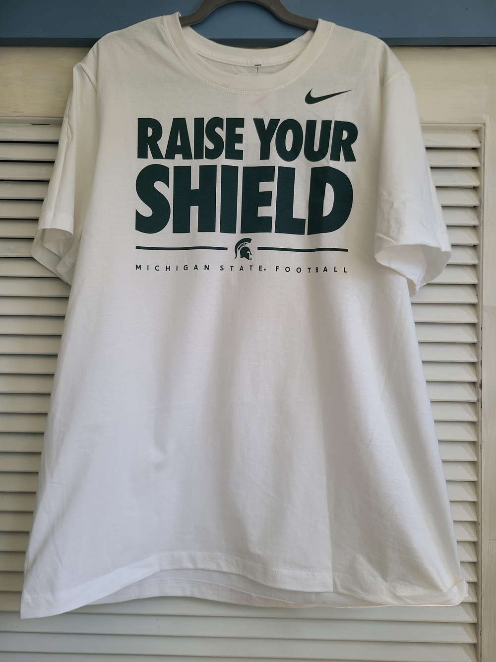 Nike White T-Shirt with Dark Green 'Raise Your Shield' Graphic